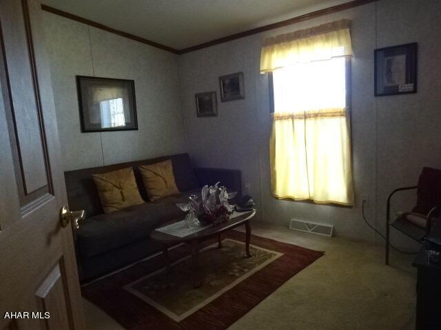 living room with carpet flooring and crown molding