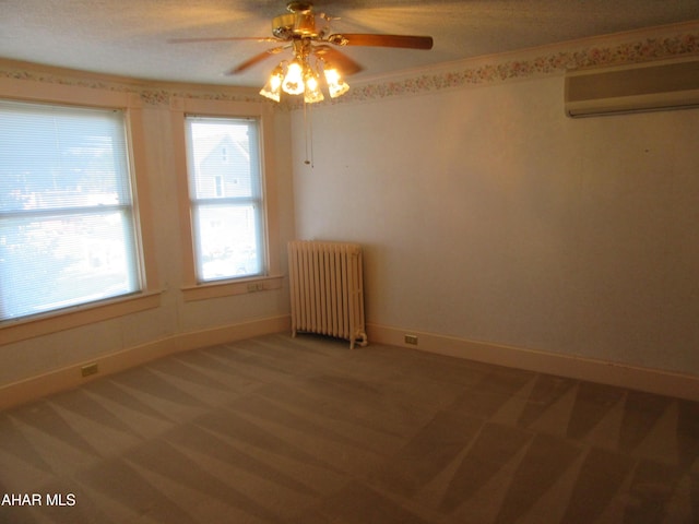 carpeted spare room with a wall mounted air conditioner, ceiling fan, a healthy amount of sunlight, and radiator