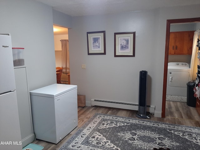 laundry room with washer / clothes dryer, dark wood-type flooring, and a baseboard radiator