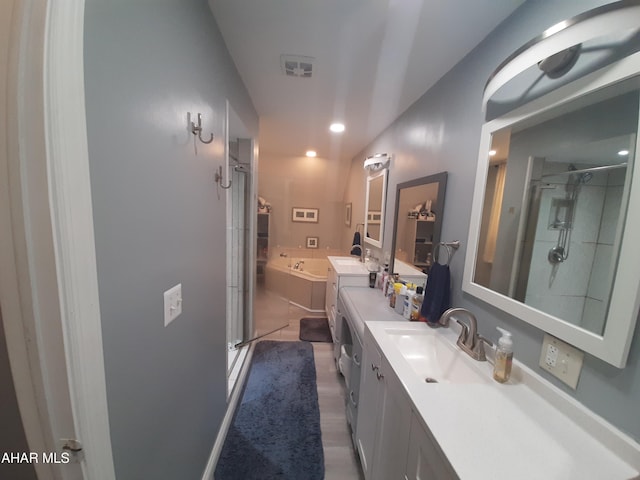 bathroom featuring hardwood / wood-style floors, vanity, and plus walk in shower