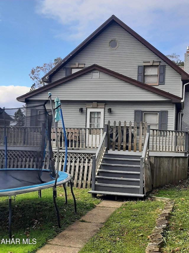 back of house featuring a deck and a trampoline