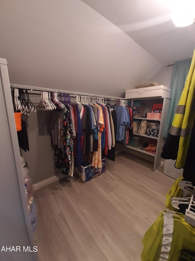 spacious closet with light hardwood / wood-style flooring and lofted ceiling