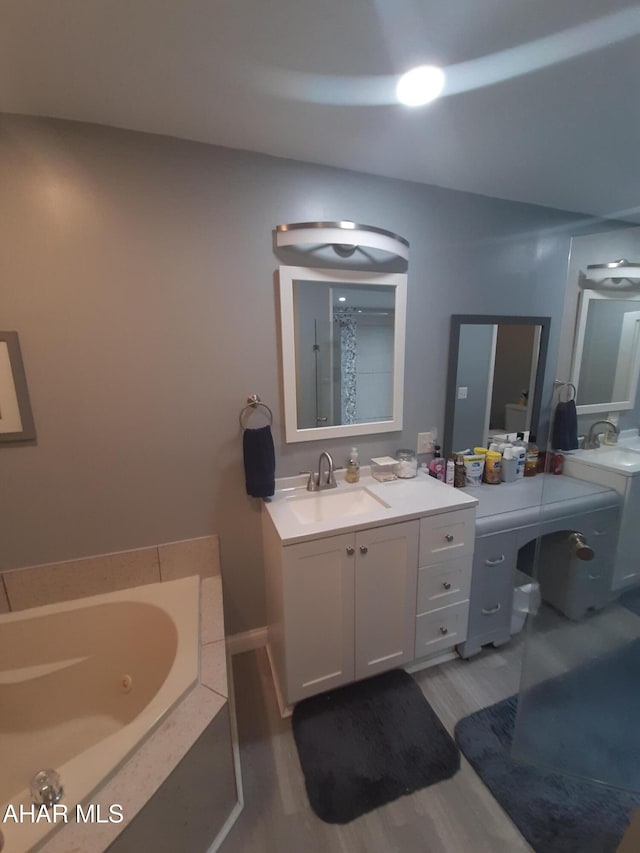 bathroom with hardwood / wood-style flooring, vanity, and a washtub