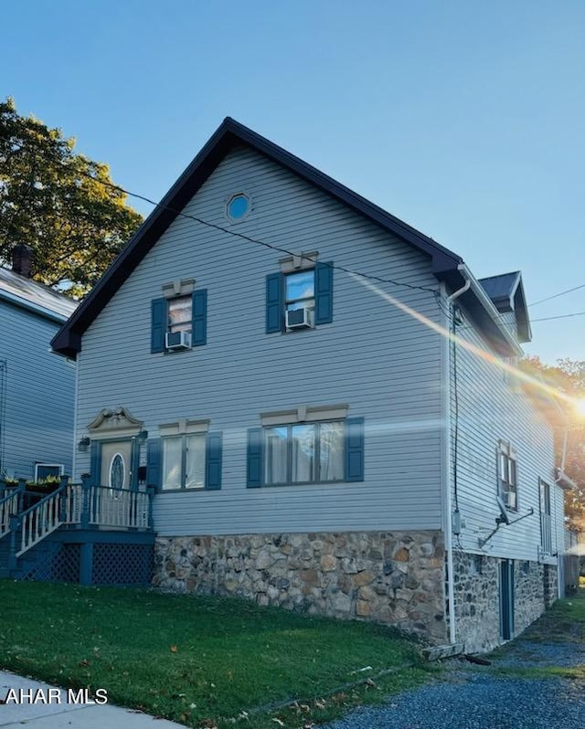 view of side of home featuring a lawn and cooling unit