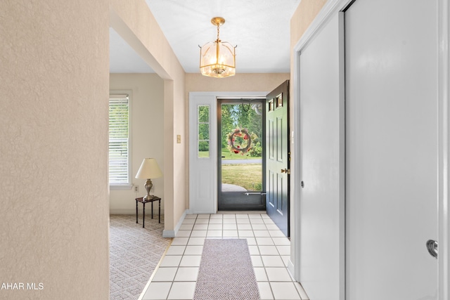 409 Tree Ln, Duncansville, PA 16635 - foyer entrance with a textured wall, a chandelier, light tile patterned floors, and baseboards