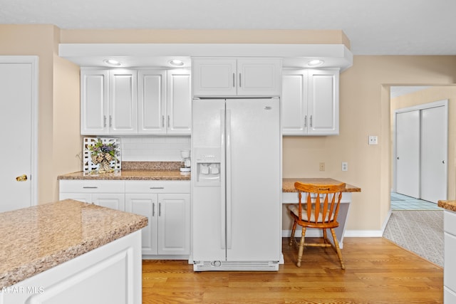 409 Tree Ln, Duncansville, PA 16635 - kitchen featuring white fridge with ice dispenser, light wood-style flooring, white cabinets, and decorative backsplash