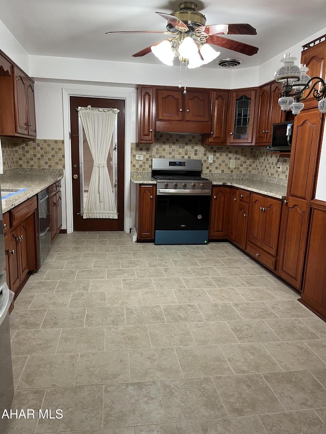 kitchen featuring visible vents, decorative backsplash, a ceiling fan, light stone countertops, and black appliances