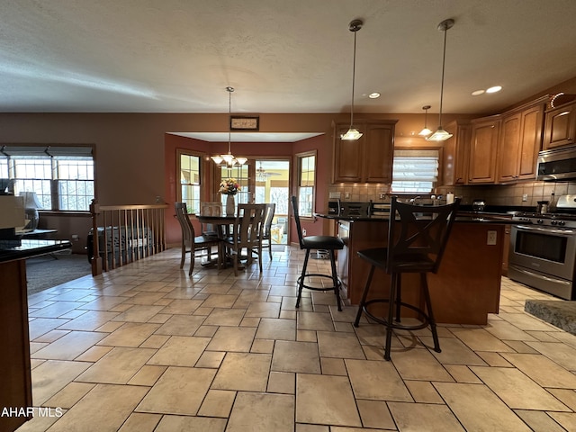 3406 Granada Way, Altoona, PA 16601 - kitchen featuring stainless steel appliances, dark countertops, decorative backsplash, a breakfast bar area, and hanging light fixtures