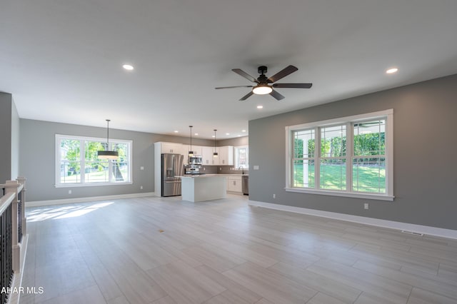 unfurnished living room featuring light wood-type flooring and ceiling fan