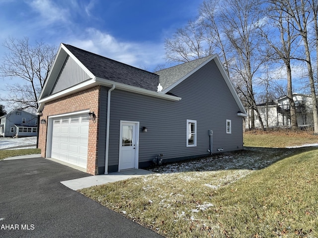 view of home's exterior with a garage and a lawn