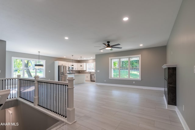 unfurnished living room with ceiling fan