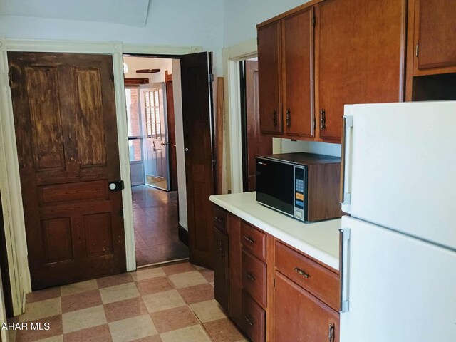 818 5th Ave, Patton, PA 16668 - kitchen with freestanding refrigerator, black microwave, light countertops, and light flooring