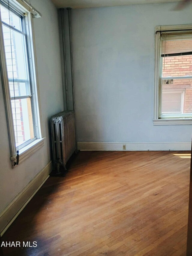 818 5th Ave, Patton, PA 16668 - empty room featuring radiator, light wood-type flooring, and plenty of natural light