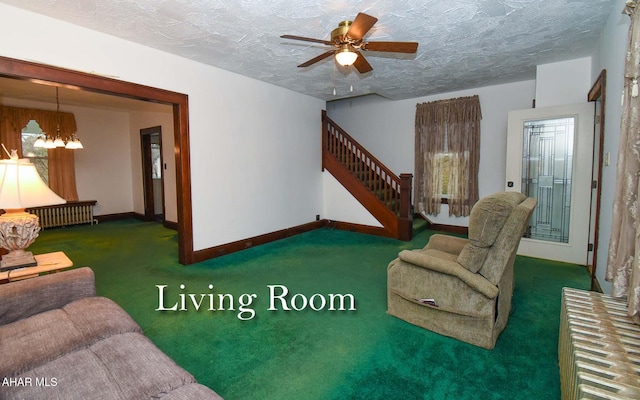 carpeted living room featuring ceiling fan with notable chandelier and a textured ceiling