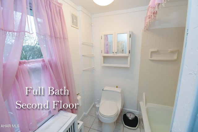 bathroom with a tub to relax in, tile patterned flooring, and toilet