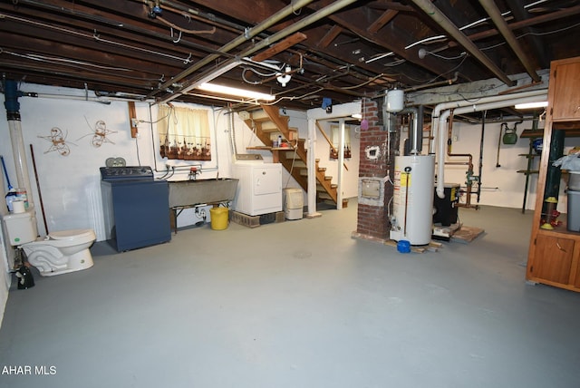 basement featuring gas water heater, sink, and washing machine and dryer