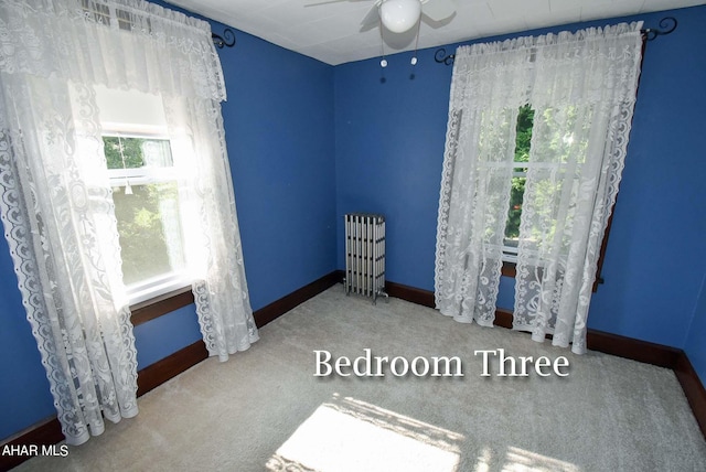 bedroom with carpet, radiator heating unit, and ceiling fan