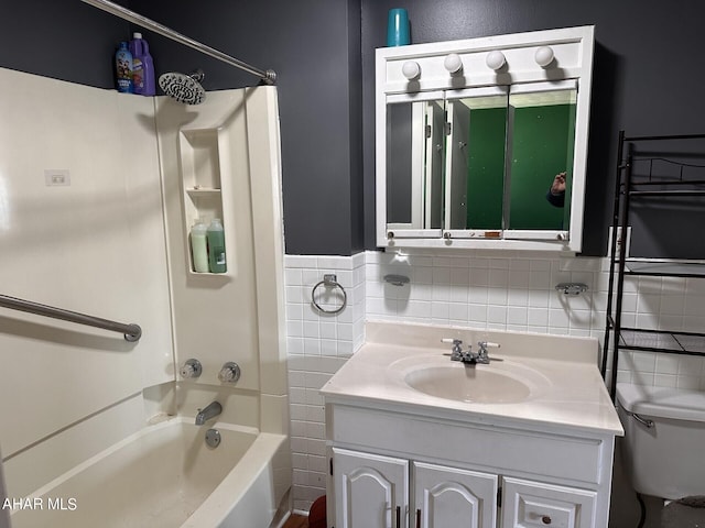 full bathroom featuring shower / bathing tub combination, vanity, toilet, and tile walls