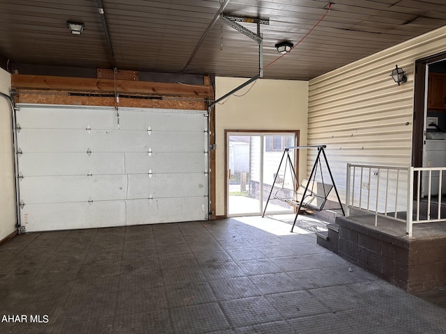 garage featuring washer / dryer, wood ceiling, and wooden walls