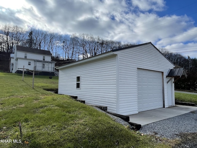 exterior space featuring a lawn, a garage, and an outdoor structure