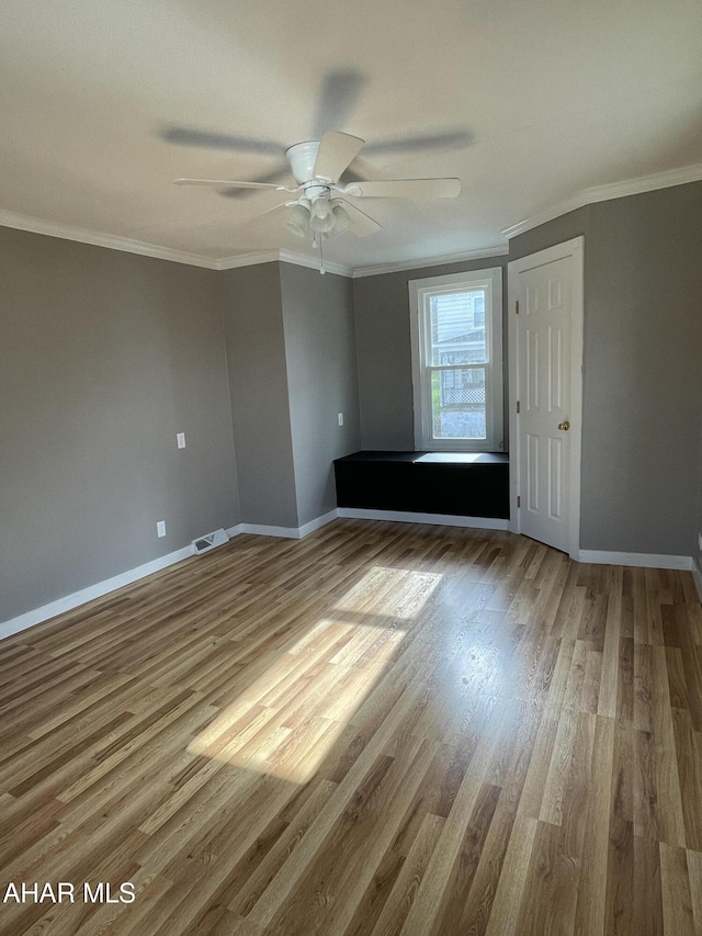 unfurnished bedroom with ceiling fan, ornamental molding, and hardwood / wood-style flooring