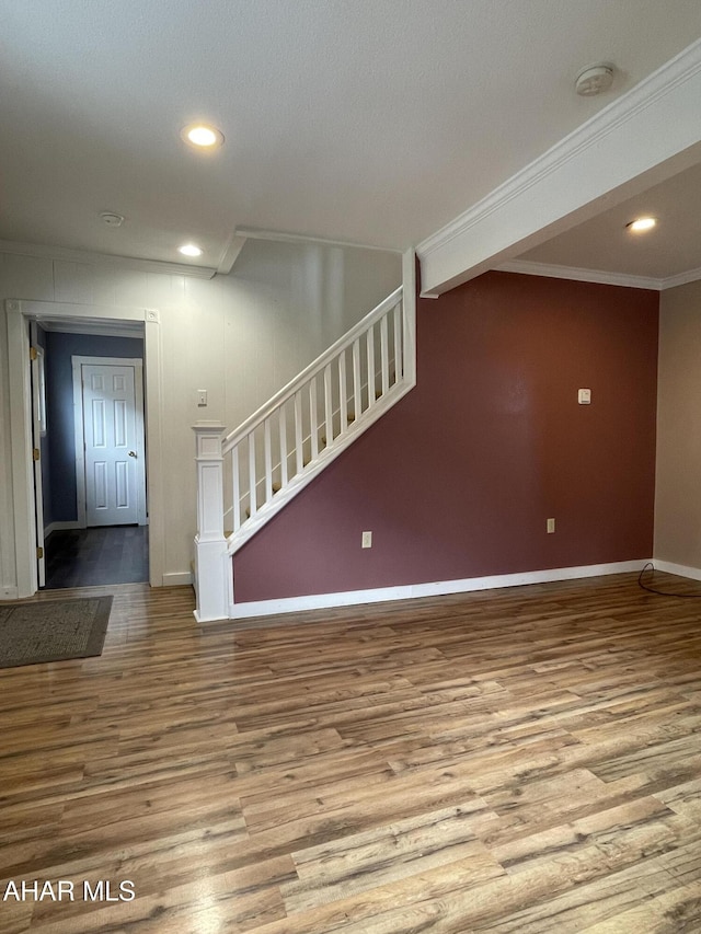 unfurnished living room featuring hardwood / wood-style floors, ornamental molding, and a textured ceiling