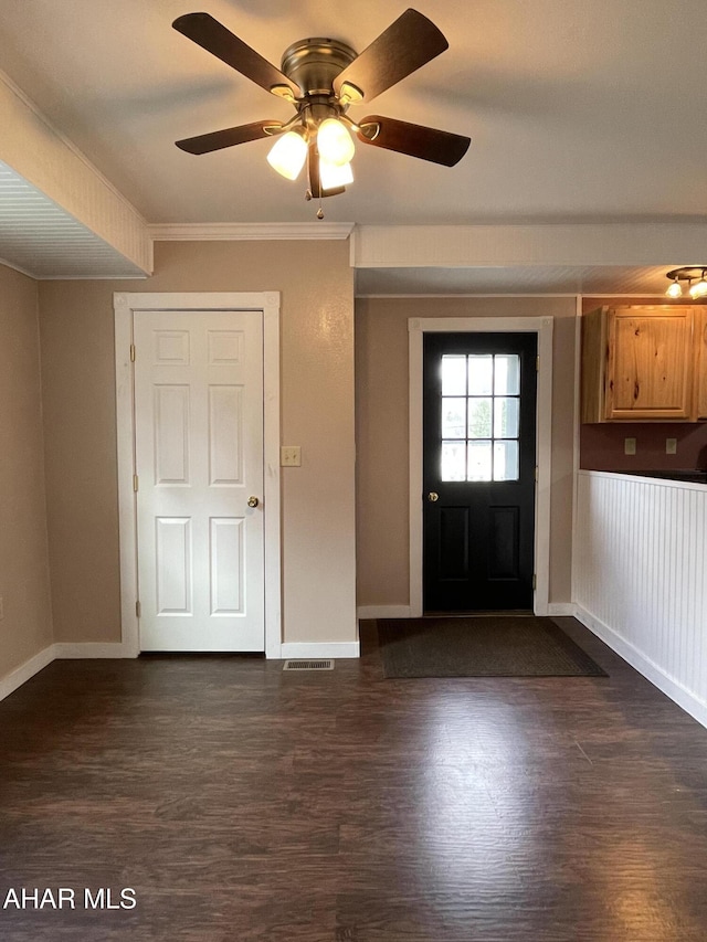 entryway with crown molding, ceiling fan, and dark wood-type flooring