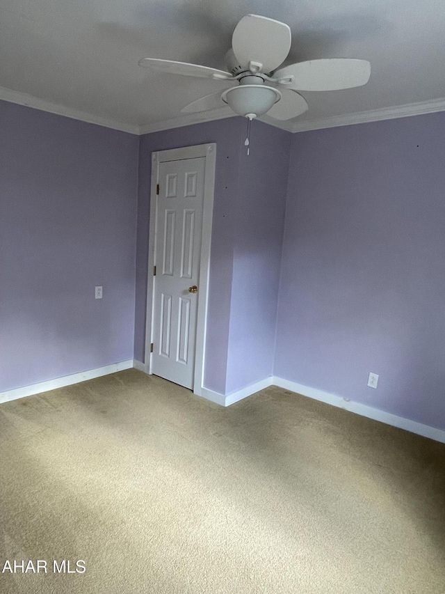 carpeted empty room featuring ceiling fan and crown molding