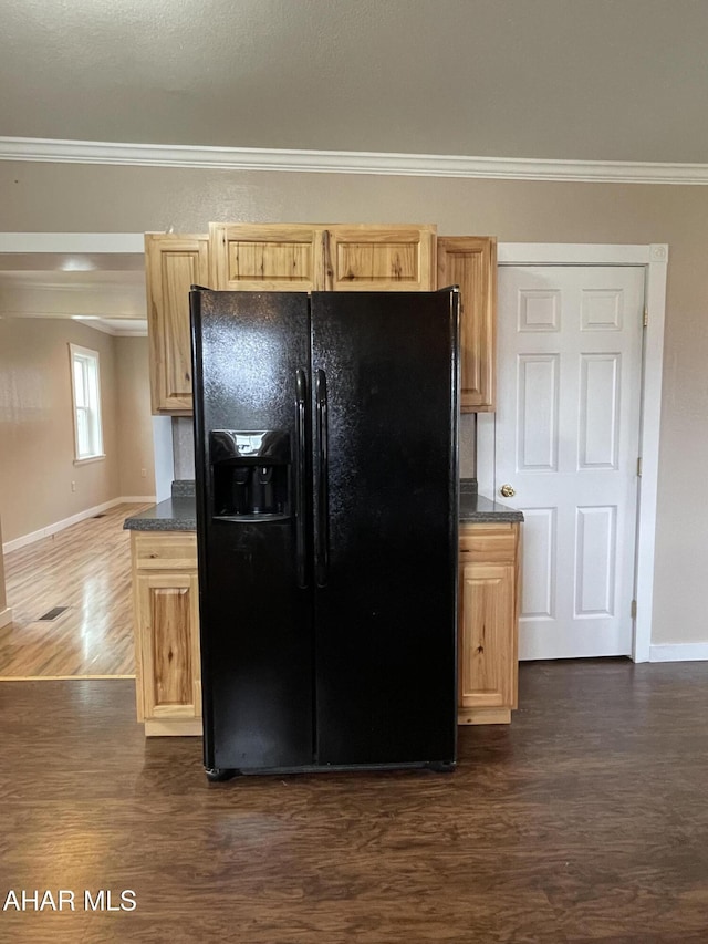 kitchen featuring light brown cabinets, dark hardwood / wood-style flooring, black fridge, and crown molding