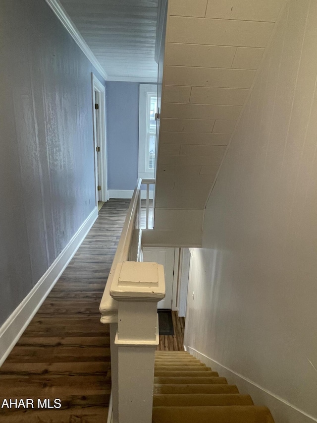 staircase with wood-type flooring and ornamental molding