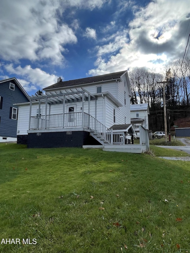 back of property with a pergola and a yard