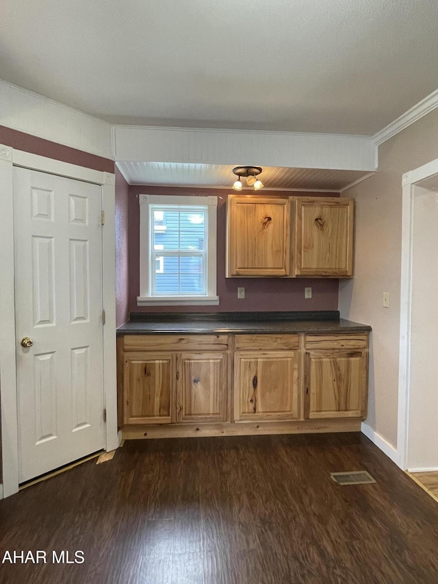 kitchen featuring dark hardwood / wood-style floors and crown molding