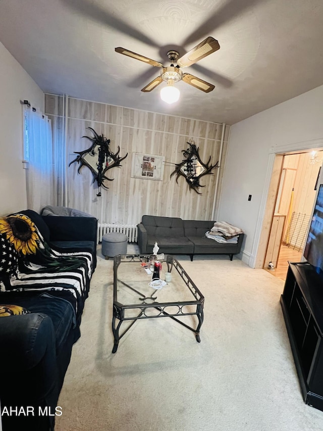 carpeted living room featuring radiator and ceiling fan