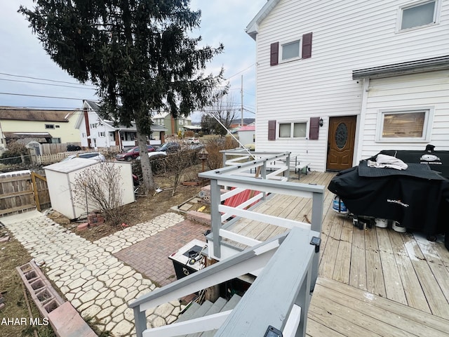 deck with a shed, grilling area, and a patio