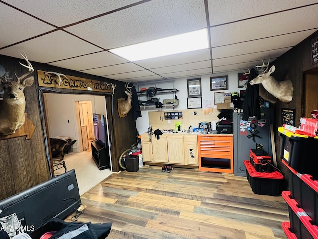 basement featuring hardwood / wood-style flooring and a paneled ceiling