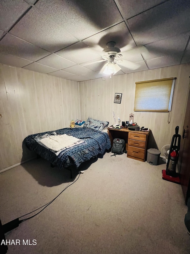 bedroom with ceiling fan, carpet floors, and a drop ceiling