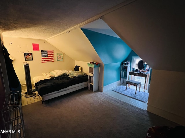 bedroom with lofted ceiling, carpet, and a textured ceiling