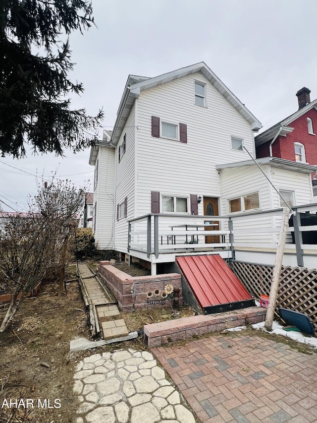 rear view of house featuring a wooden deck