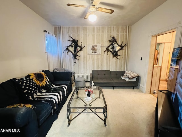 carpeted living room featuring radiator and ceiling fan