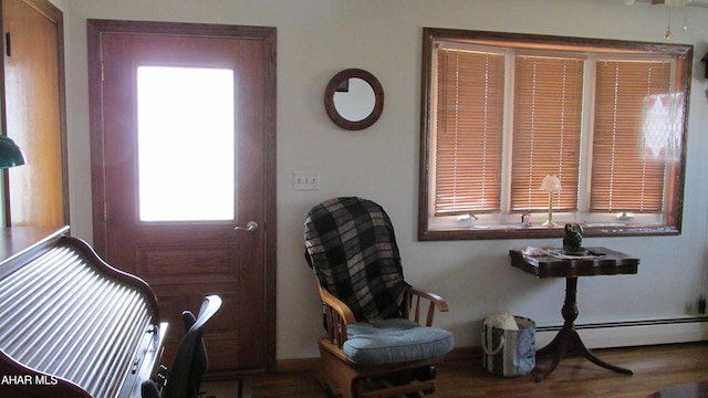 foyer entrance featuring a baseboard radiator and wood finished floors