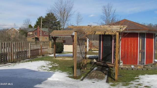 yard layered in snow featuring an outbuilding and fence