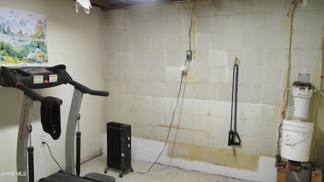 exercise room featuring concrete block wall