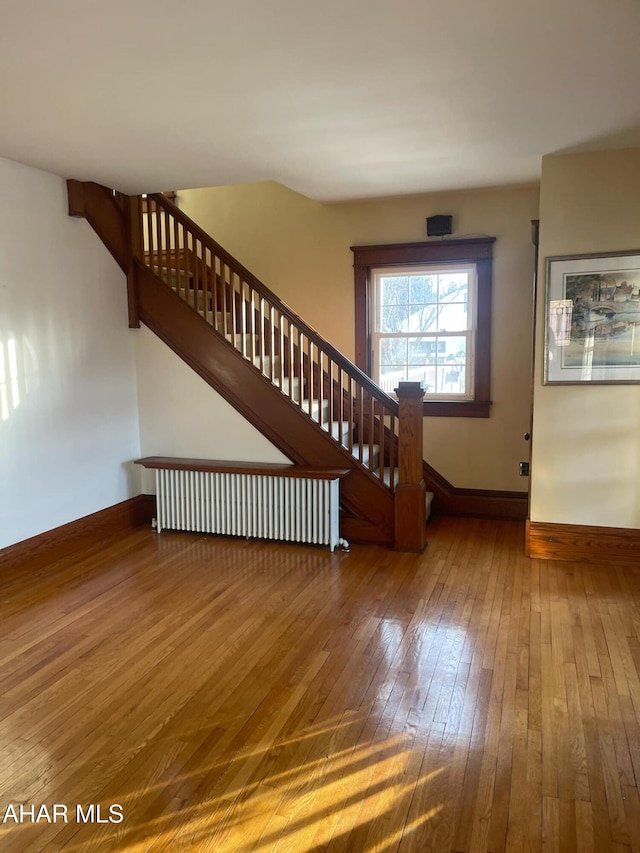 staircase featuring hardwood / wood-style flooring and radiator