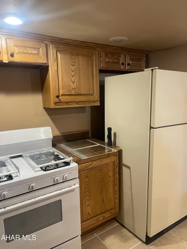 kitchen with white appliances and light tile patterned floors