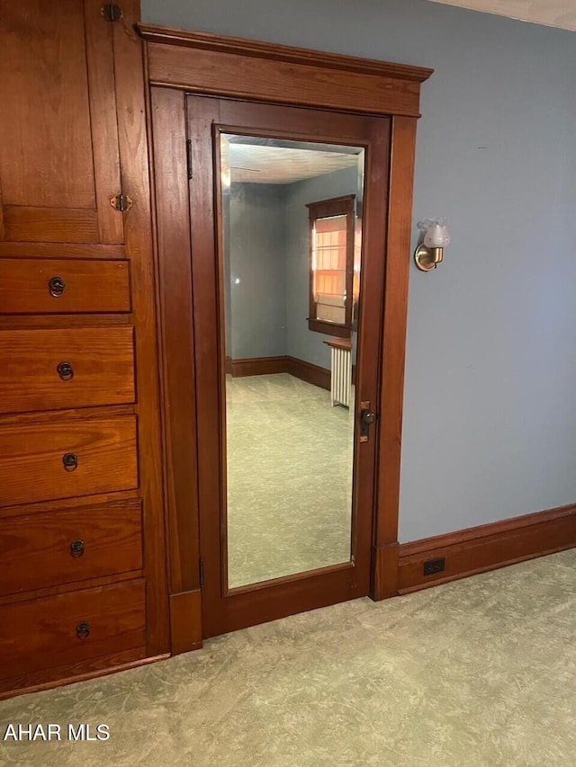 interior space with radiator heating unit and light colored carpet