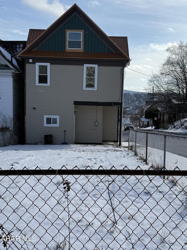 view of snow covered rear of property