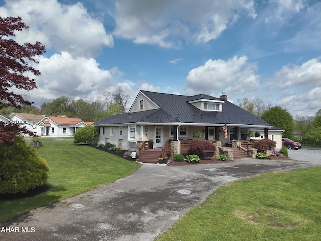 605 13th St, Duncansville, PA 16635 - farmhouse featuring covered porch, a front yard, a chimney, metal roof, and driveway