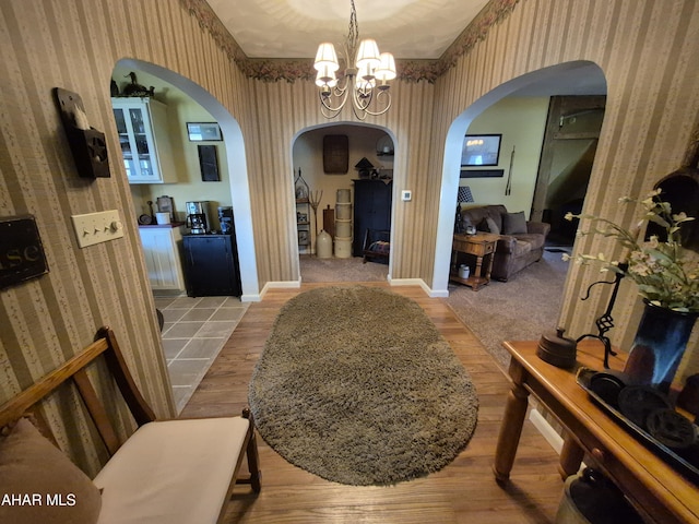 605 13th St, Duncansville, PA 16635 - interior space featuring arched walkways, wood finished floors, baseboards, a chandelier, and wallpapered walls