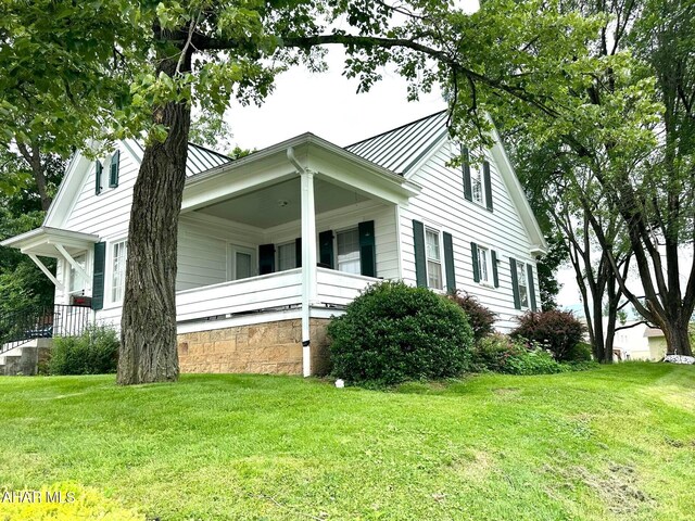 132 S Thomas St, Bedford, PA 15522 - view of property exterior featuring a standing seam roof, a lawn, a metal roof, and a porch