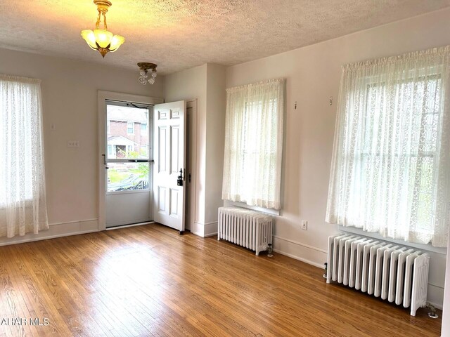 132 S Thomas St, Bedford, PA 15522 - empty room with radiator, wood finished floors, and a textured ceiling